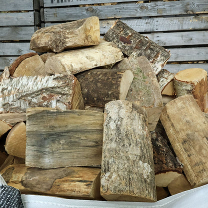 Stack of hardwood firewood logs against a wooden background