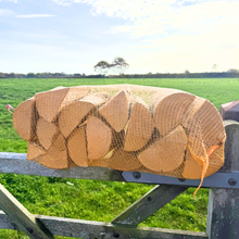 Netted kiln dried ash logs on a gate