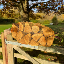 Netted kiln dried oak logs on a gate