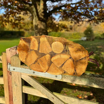 Netted kiln dried oak logs on a gate