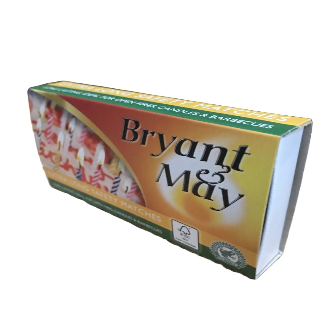 A pack of Bryant & May safety matches, with a green and yellow label, placed on a wooden surface.