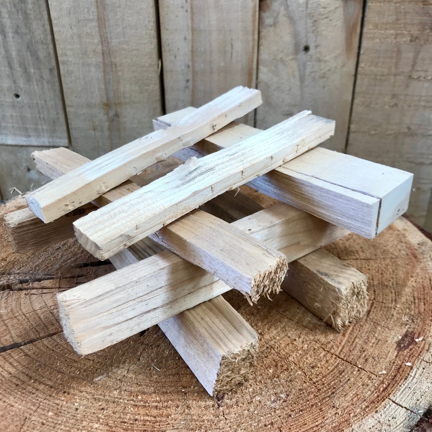 Kindling sticks are stacked on a chopping block in a jenga style 