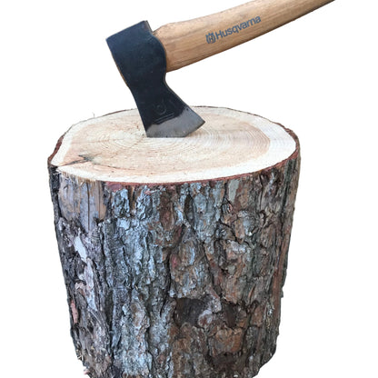 A chopping block with an axe embedded in it, showing the wood grain and a portion of the axe handle.